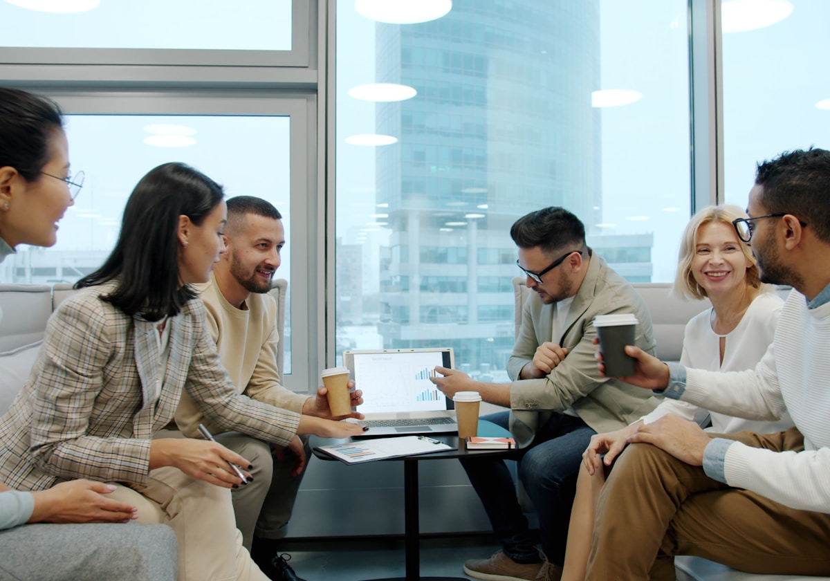 A diverse technology team discussing work around a laptop